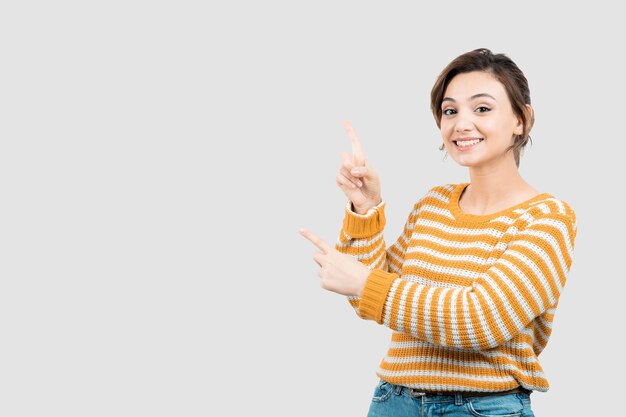 Picture of a young woman standing and pointing up