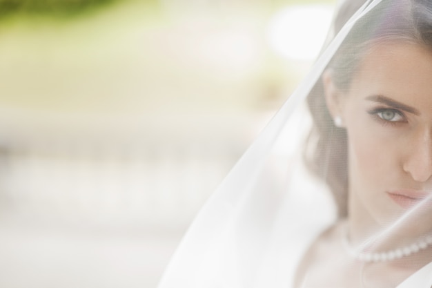 Pictures of stunning bride posing under the veil outside