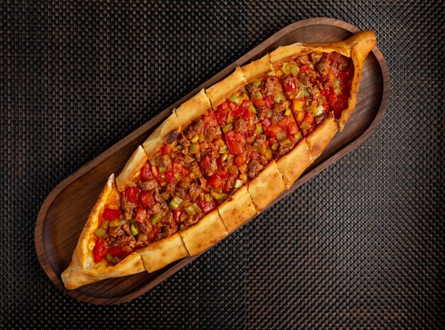 Pide с кусочками мяса и перца на деревянной миске