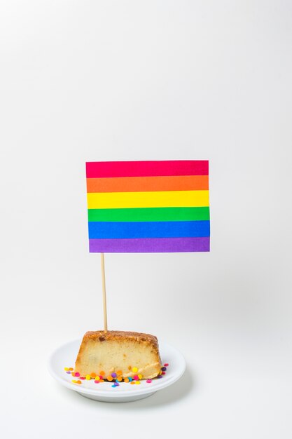 Pie on plate with bright LGBT paper flag with stick