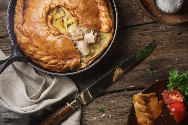 Pie on stainless steel bowl beside black handled knife