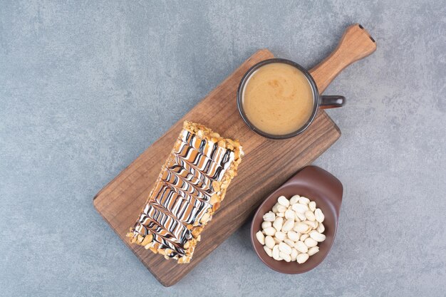 A piece of cake with cup of aroma coffee on gray surface 