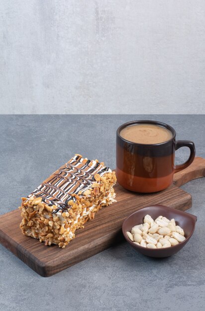 A piece of cake with cup of aroma coffee on gray table .