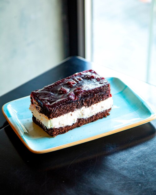 piece of chocolate cake with cream on a blue plate