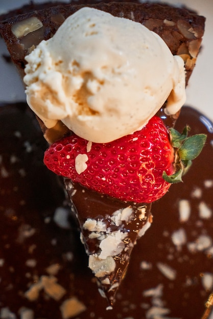 Piece of chocolate cake with strawberry and ice cream