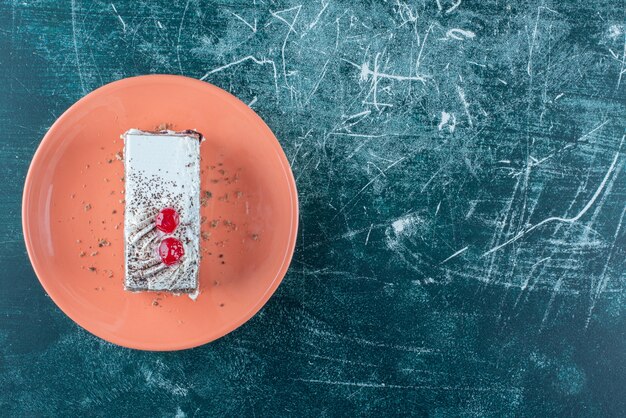 오렌지 접시에 딸기와 함께 맛있는 케이크 한 조각. 고품질 사진