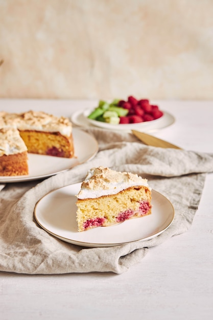 Piece of the delicious raspberry cake with baiser on a plate