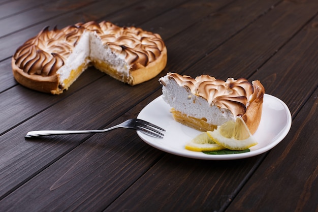 화이트 크림 레몬 파이의 조각 흰색 접시에 제공