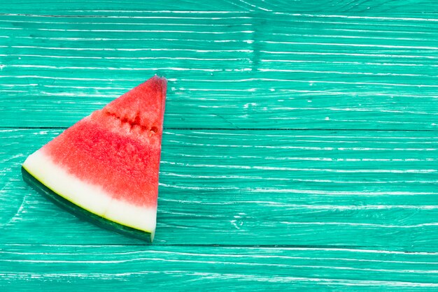 Piece of  red juicy watermelon on green background