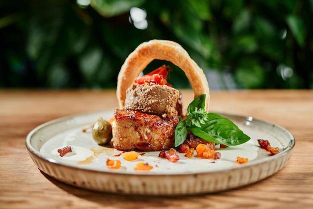 Free photo piece of roasted meat served with breaded squid ring