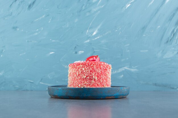 Piece of strawberry cake on blue plate.