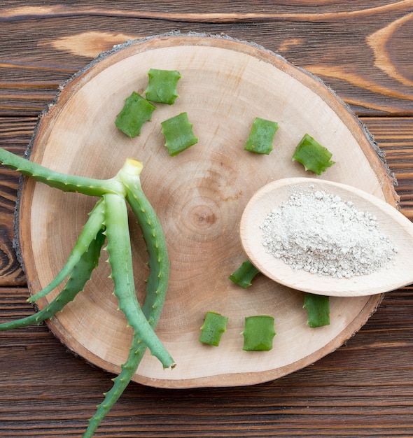 Pieces of aloe vera leaves on wooden coaster