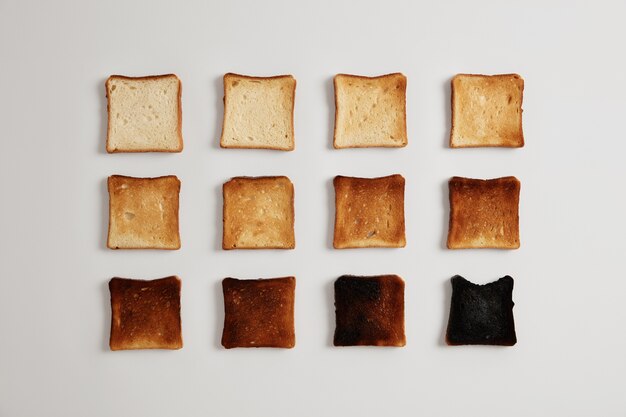 Pieces of bread browned as result of toasting. Delicious crust tender slices of bread prepared in toaster which may be served with spreads or toppings, isolated on white surface. Stages of burning.