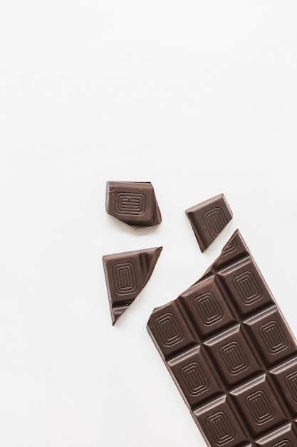 Pieces of dark chocolate bar isolated over white background