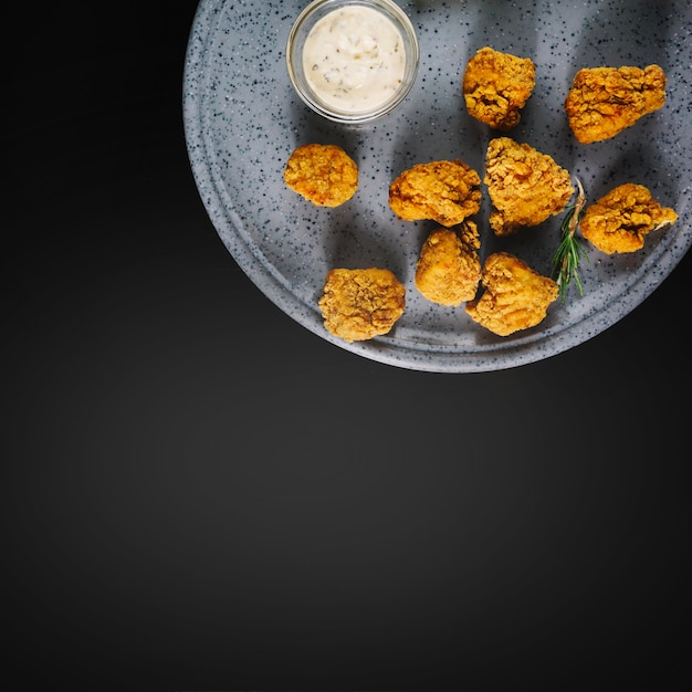 Pieces of fried chicken near tasty sauce