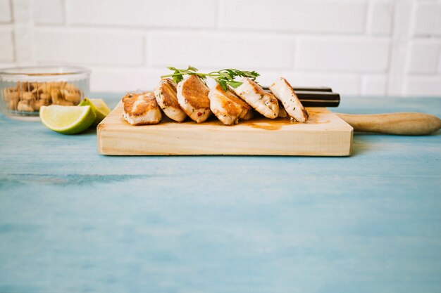 Pieces of grilled meat on cutting board