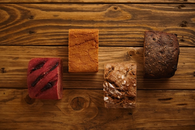 サツマイモから作られた販売用サンプルとして、木製のテーブルにさまざまなレベルで提示された自家製の混合パンの断片