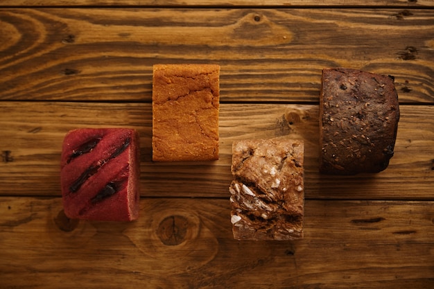 Pieces of mixed homemade breads presented in different levels on wooden table as samples for sale made from sweet potato