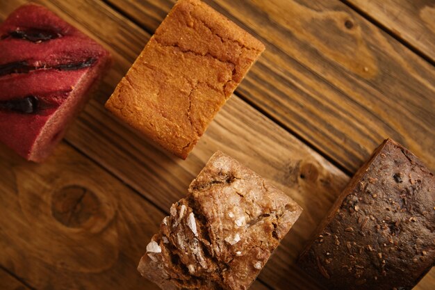 판매용 샘플로 나무 테이블에 다양한 수준으로 제시된 혼합 수제 빵 조각 :