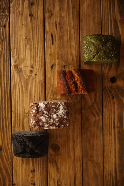 Pieces of mixed homemade breads presented on wooden table as samples for sale: pistachio