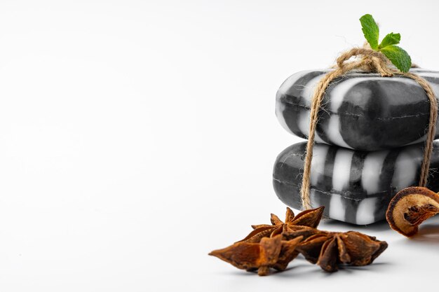 Pieces of natural black handmade soap on white background