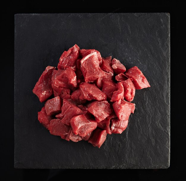 石板の黒で分離された生の新鮮な肉の断片