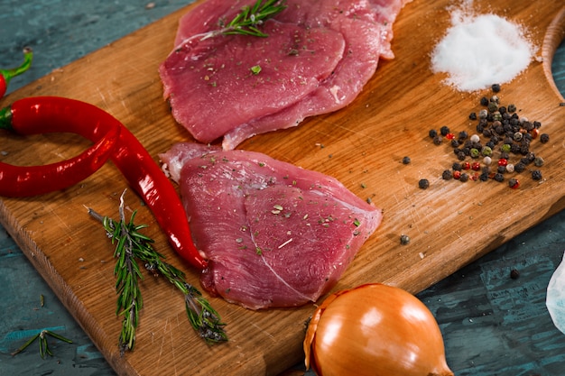 Pieces of raw pork steak with spices and herbs rosemary