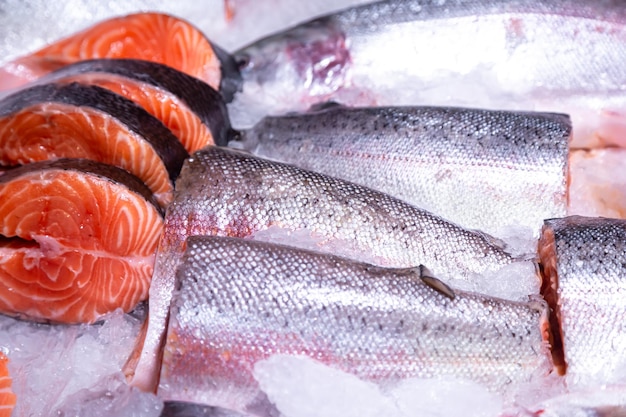 Foto gratuita pezzi di bistecca cruda di salmone fresco sdraiati sul bancone del ghiaccio