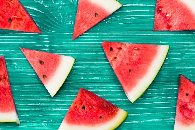 Pieces of red watermelon on green background