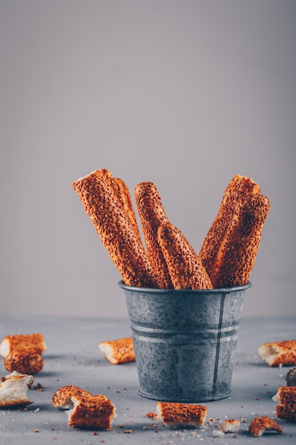 Pieces of turkish bagel in a bowl on a gray surface side view.