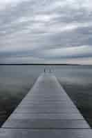 Free photo pier over lake against cloudy sky