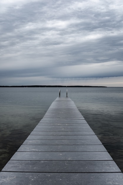 Pier over lake against cloudy sky