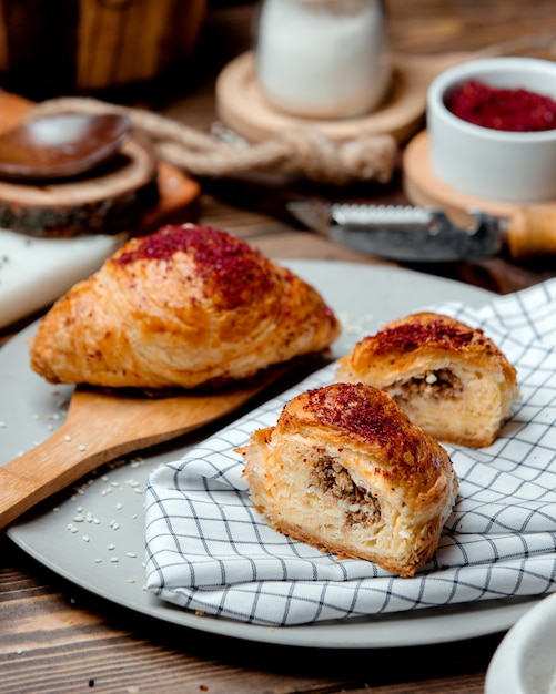 Pies with meat from puff pastry sprinkled with sumac on a plate