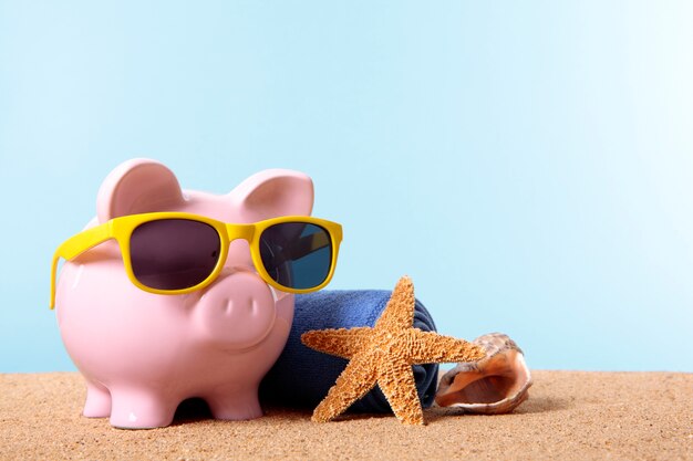 Piggy bank on a beach with sunglasses 