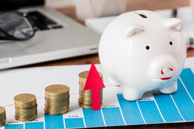 Piggy bank and growth chart with laptop and coins