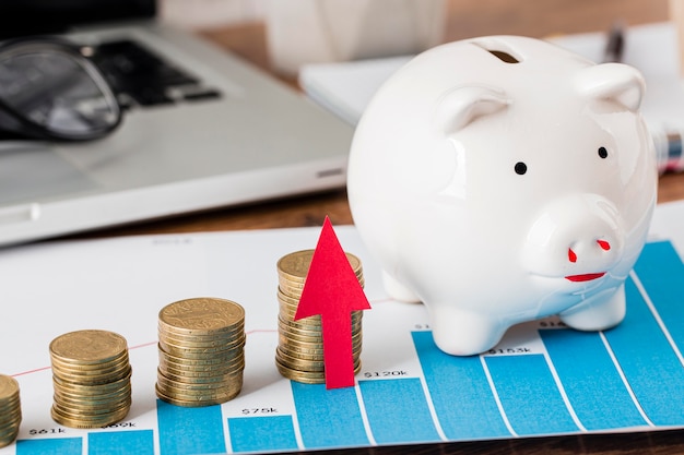 Piggy bank and growth chart with laptop and coins