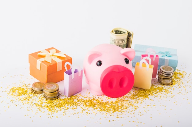 Free photo piggy bank with money and gift boxes