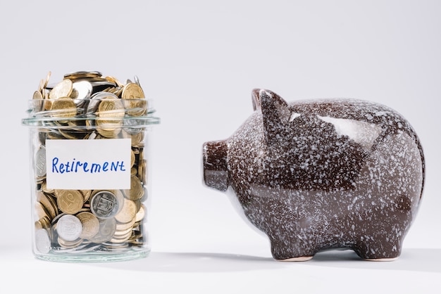 Piggybank near retirement glass container full of coins