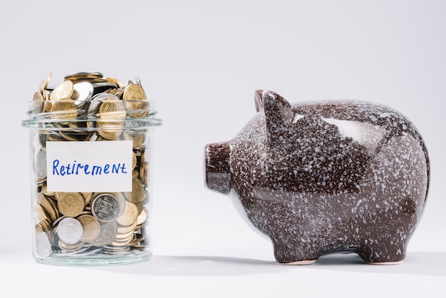 Free Photo piggybank near retirement glass container full of coins