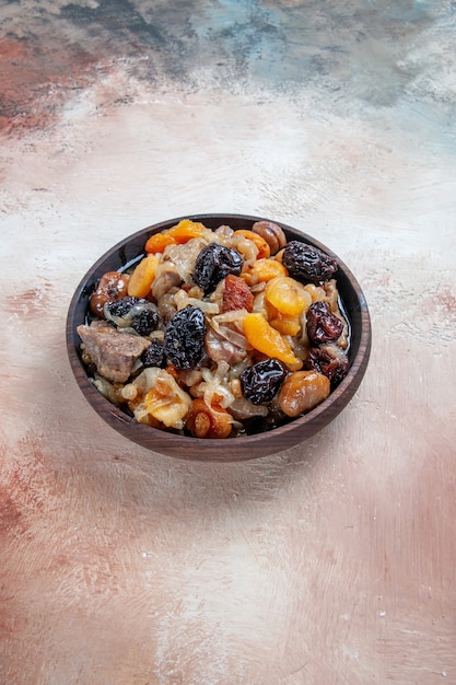 Free photo pilaf an appetizing rice with dried fruits chestnuts in the bowl