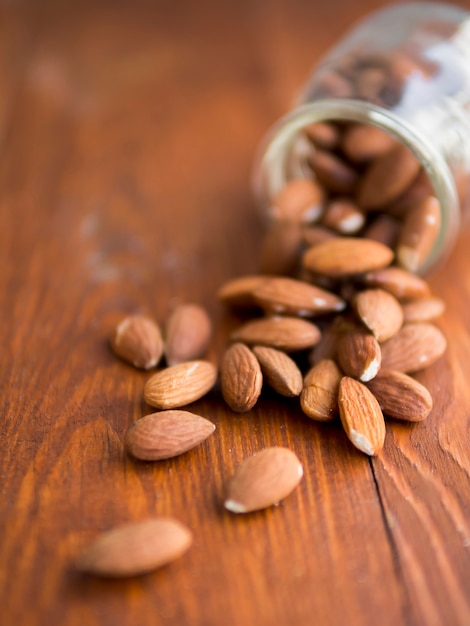 Free photo pile of almonds inside a fallen jar