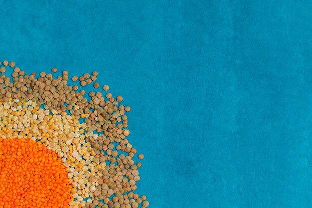 Pile of assorted lentils on blue plaster surface