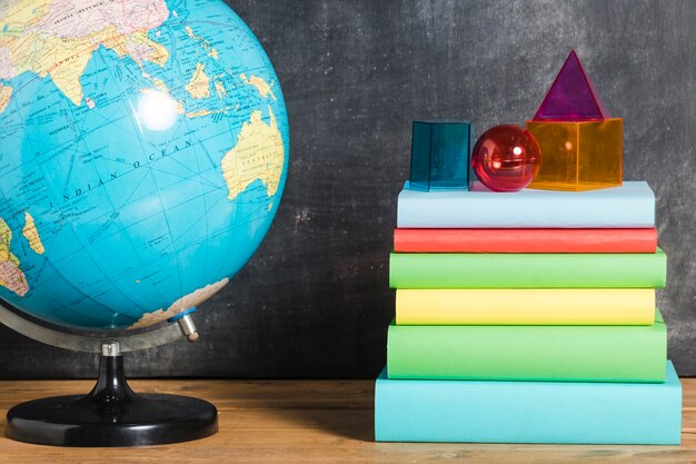 Pile of books near earth globe