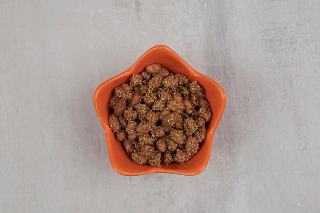 Free photo pile of candies with sesame seeds in orange bowl.