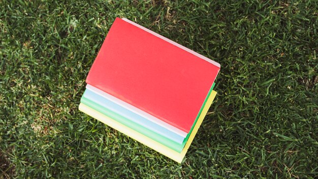 Pile of colorful books on grass