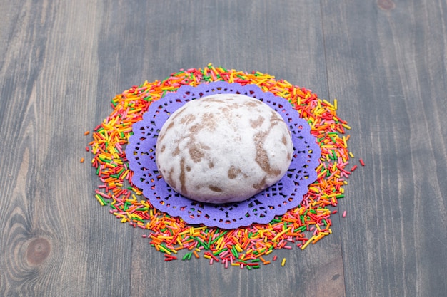 Free photo pile of colorful sprinkles around sweet cookie