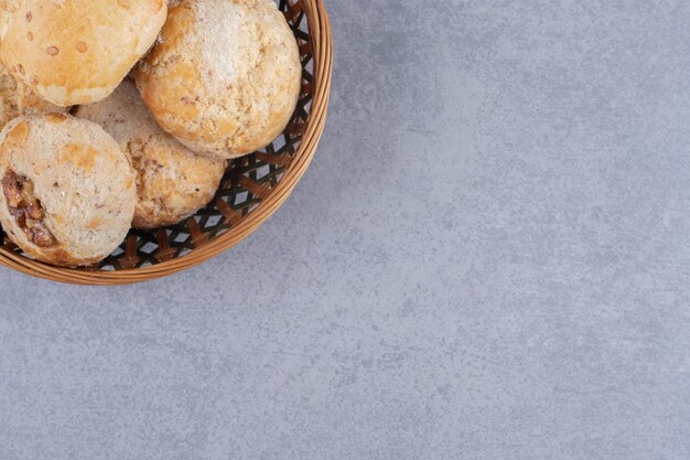 Pile of cookies in a basket on marble surface