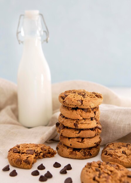 Pile of cookies and bitten cookie with milk
