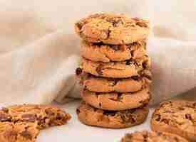 Foto gratuita pila di biscotti con gocce di cioccolato davanti al panno