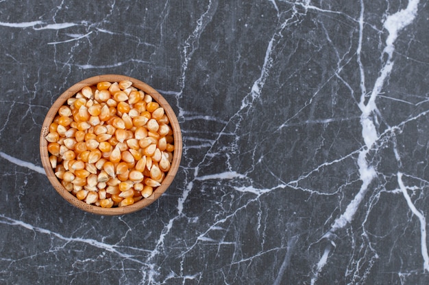 Pile of corn seeds in wooden bowl.